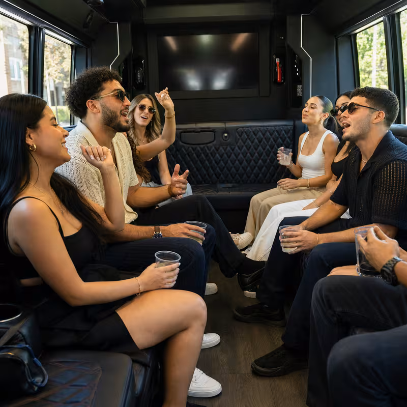 Group boarding a white charter bus for Concert Transportation transportation in Hialeah