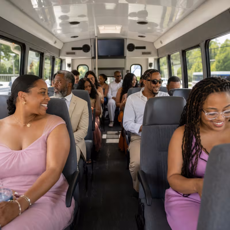 Group boarding a white charter bus for Private Event Transportation transportation in Hialeah