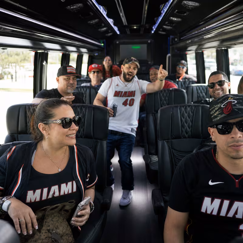 Group boarding a white charter bus for Sporting Event Transportation transportation in Hialeah