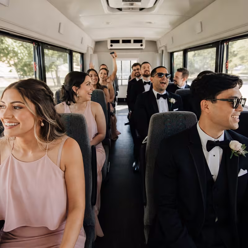 Group boarding a white charter bus for Wedding Transportation transportation in Hialeah